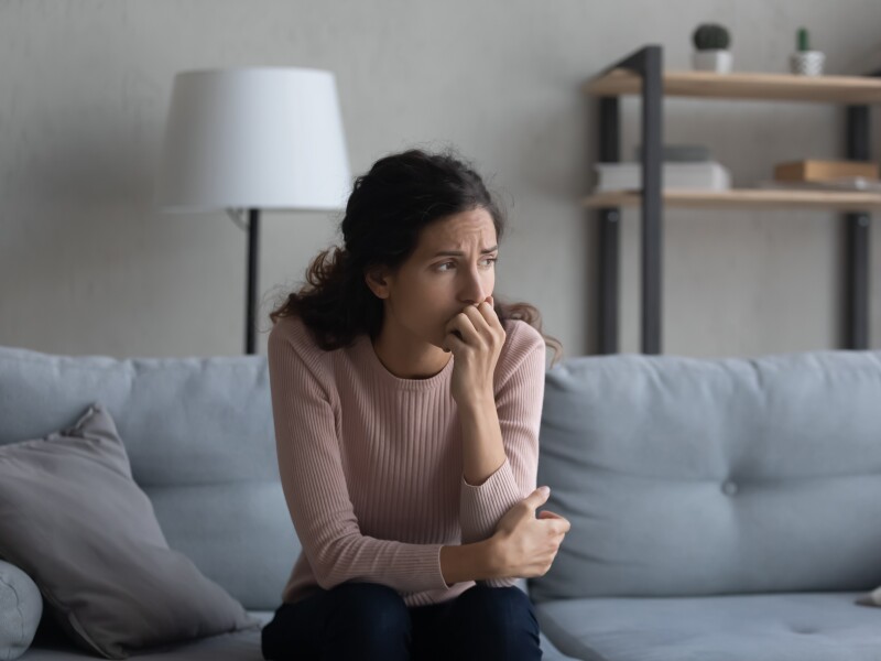 Sad,Young,Caucasian,Woman,Sit,On,Couch,At,Home,Look