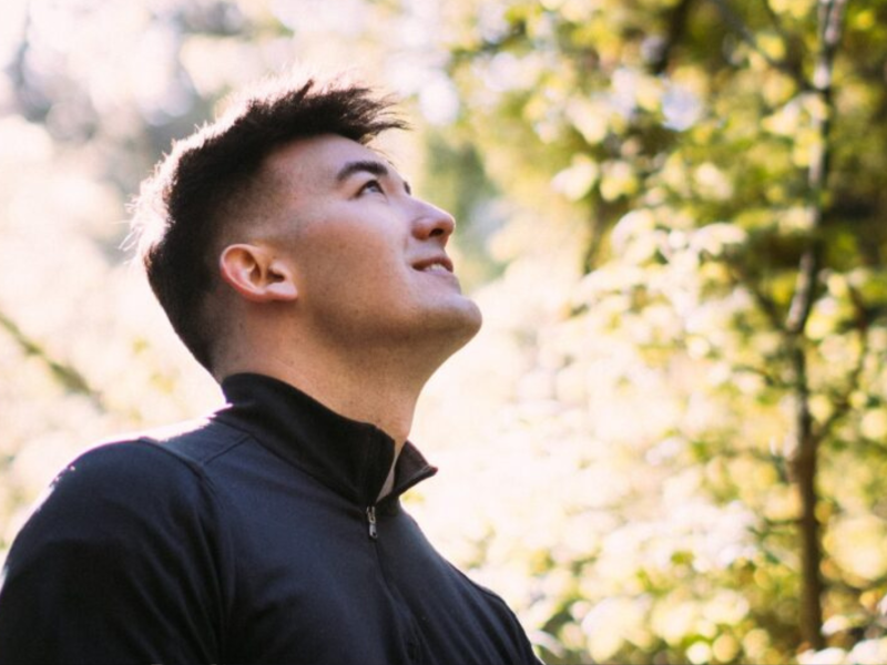 Brandon Pak looks up at a grove of trees.
