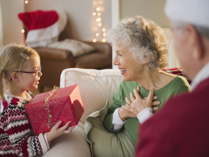Granddaughter giving Christmas present to Grandma