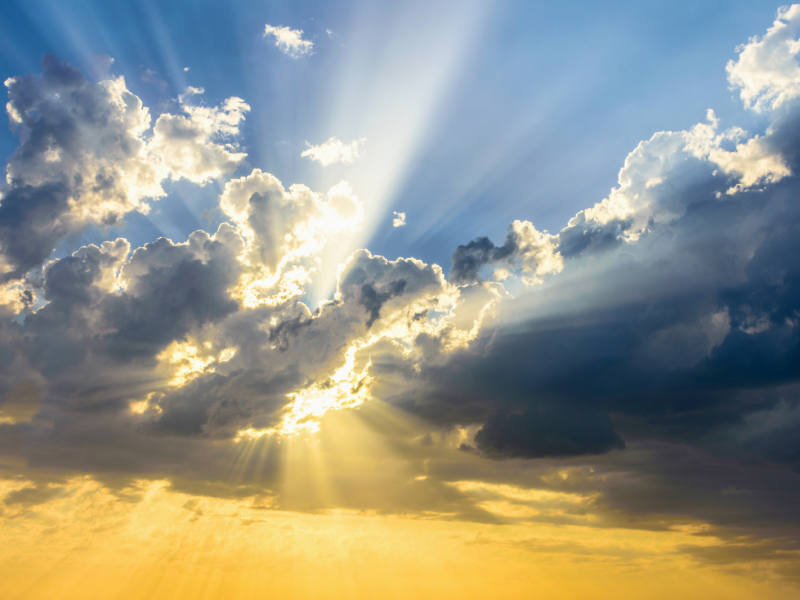 Sun beams breaking through the clouds at sunset