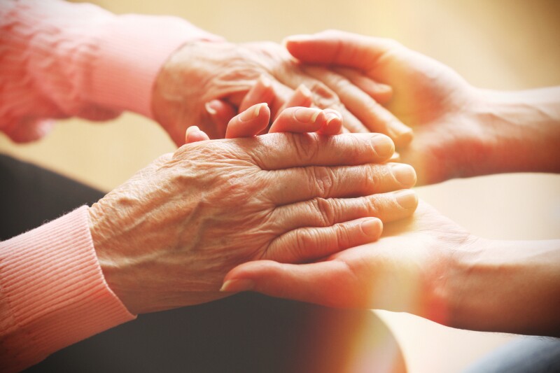 Old,And,Young,Holding,Hands,On,Light,Background,,Closeup