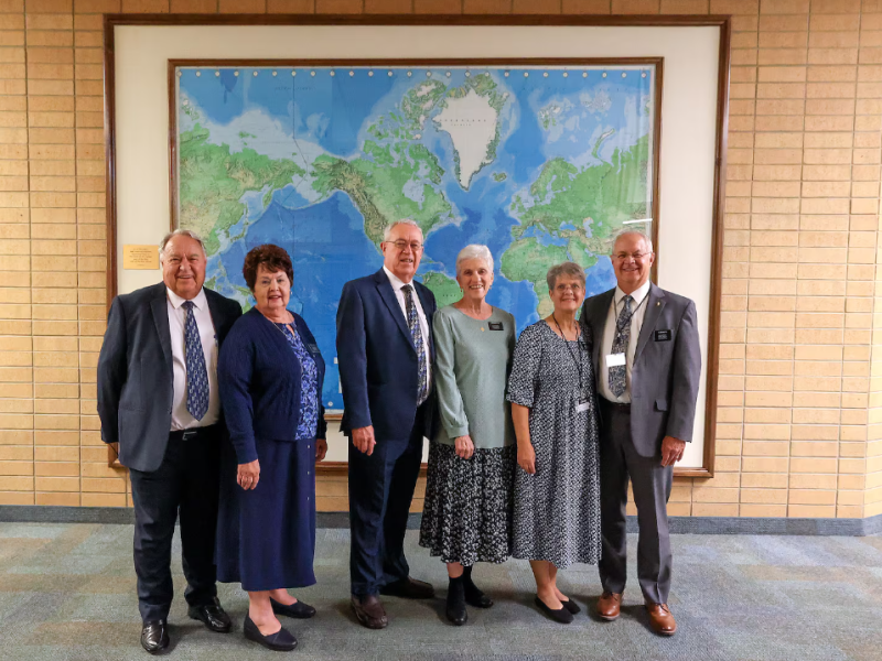 From left: Elder Robert Hatch and Sister Sharon Hatch; Elder John Hatch and Sister Sandra Hatch; and Sister Janice Hatch and Elder Paul Hatch stand in front of a map of the world at the Provo Missionary Training Center in Provo, Utah, on Tuesday, October 8, 2024.