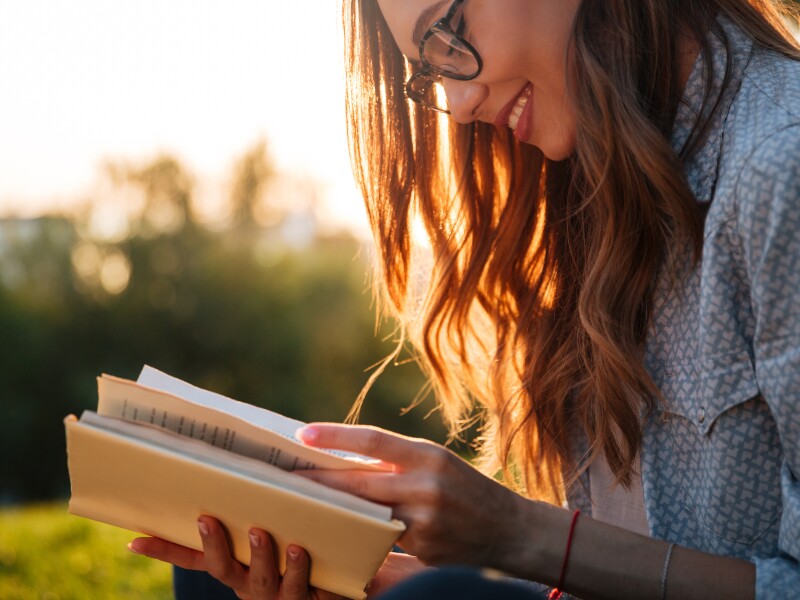 Cropped,Image,Of,Smiling,Brunette,Woman,In,Eyeglasses,Reading,Book