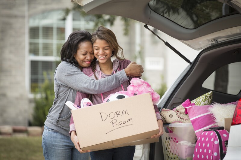 African American mother helping daughter pack for college