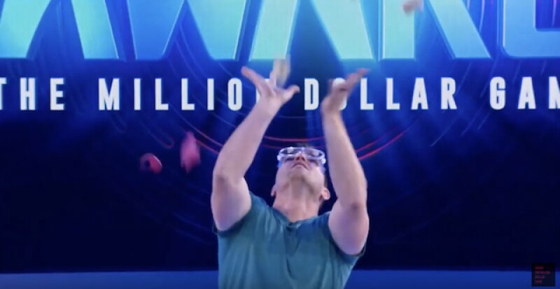 Laric during another challenge on Awake where he had to try to catch money falling from a popped balloon. (Image screenshot from YouTube)