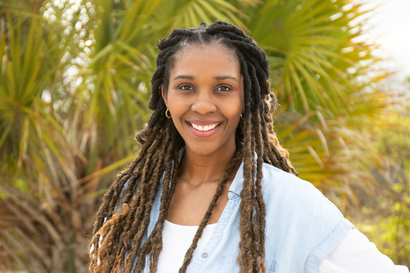 Sierra Larson from Brandon, Florida, smiles standing in front of palm trees.