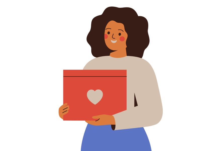A woman holds a gift box with a heart symbol on the front