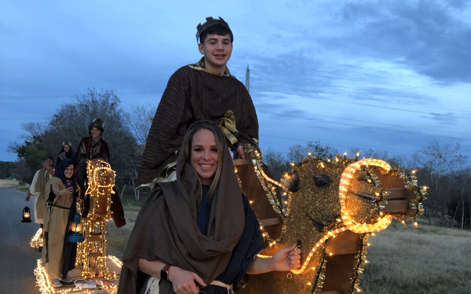 Parents guide their children on the wooden camels of the float.