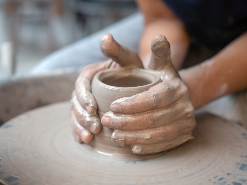 Close-up female hands working on the pottery wheel