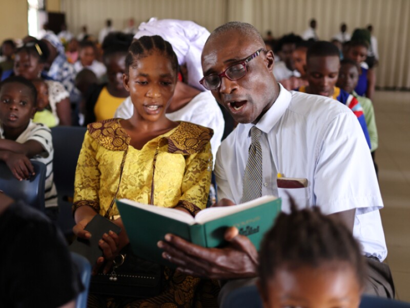 A congregation in a Latter-day Saint chapel sings from the hymnbook.