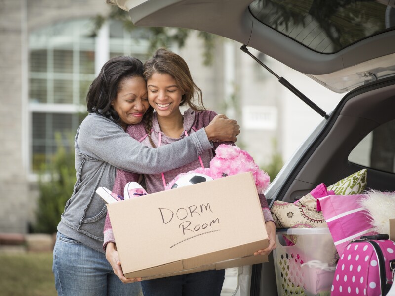 African American mother helping daughter pack for college