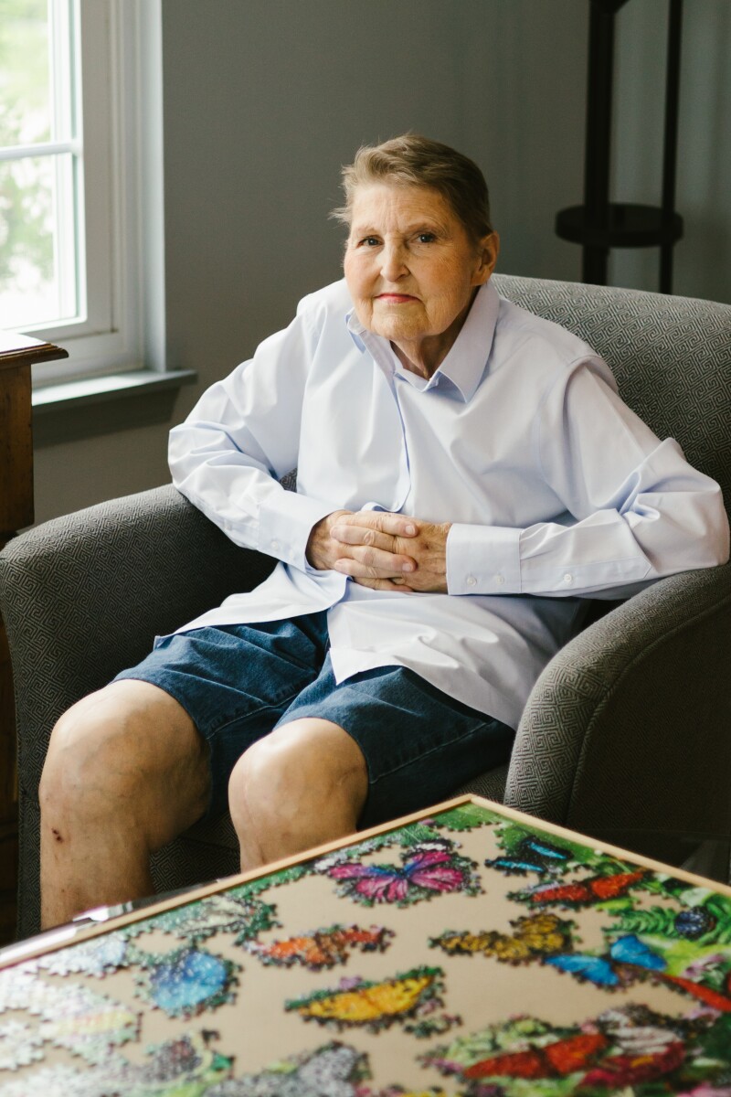 A portrait of a woman smiling near a puzzle.