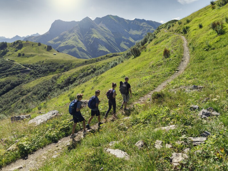 Father and teenage kids hiking in the high mountains of Austria (Alps, Vorarlberg)
