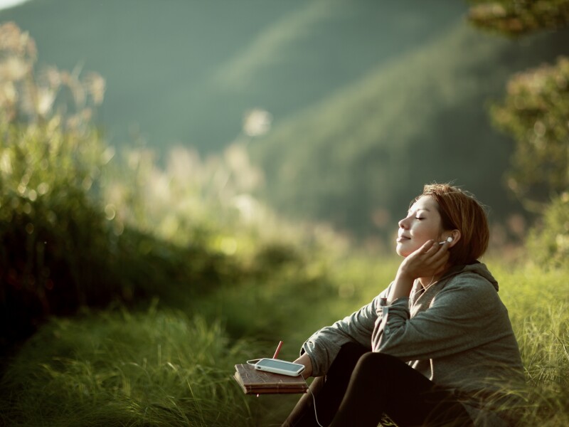 young woman listening to music outside