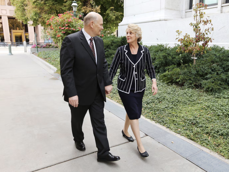 Elder Dale G. Renlund and Sister Ruth Lybbert Renlund walk hand in hand in Temple Square.