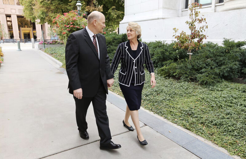 Elder Dale G. Renlund and Sister Ruth Lybbert Renlund walk hand in hand in Temple Square.