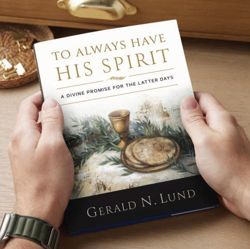 A pair of hands hold the book "To Always Have His Spirit" by Gerald N. Lund.