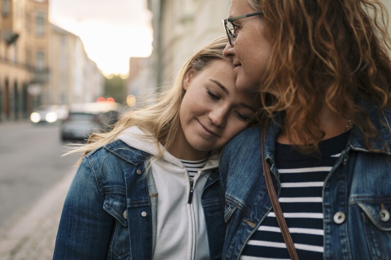 Smiling mother and daughter in city