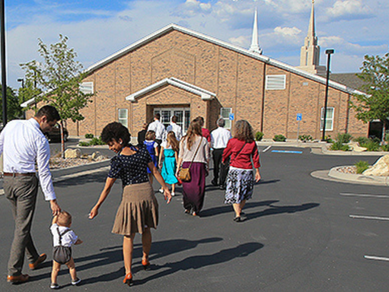 Families walking into a chapel for the Church of Jesus Christ of Latter-day Saints.