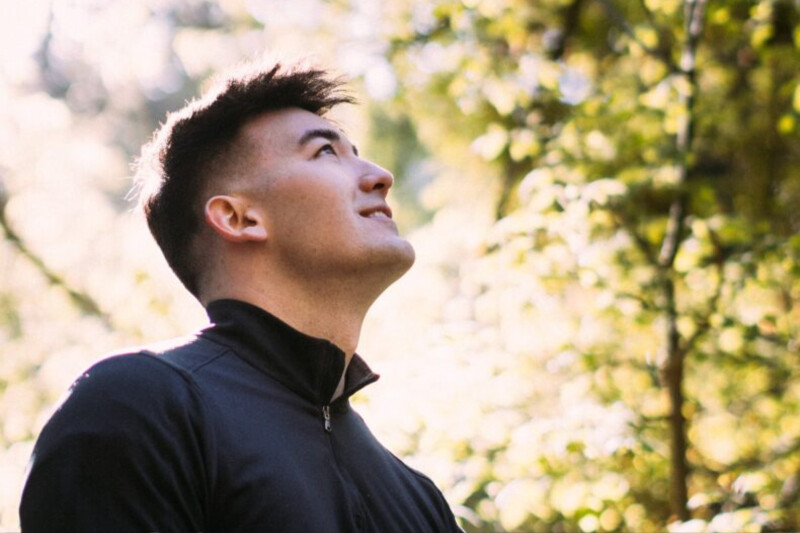 Brandon Pak looks up at a grove of trees.