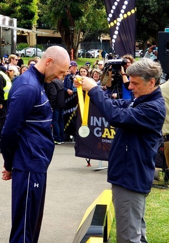 Retired Air Force Technical Sgt. Joshua D. Smith is presented with a silver medal at the 2018 Invictus Games in Australia in October.