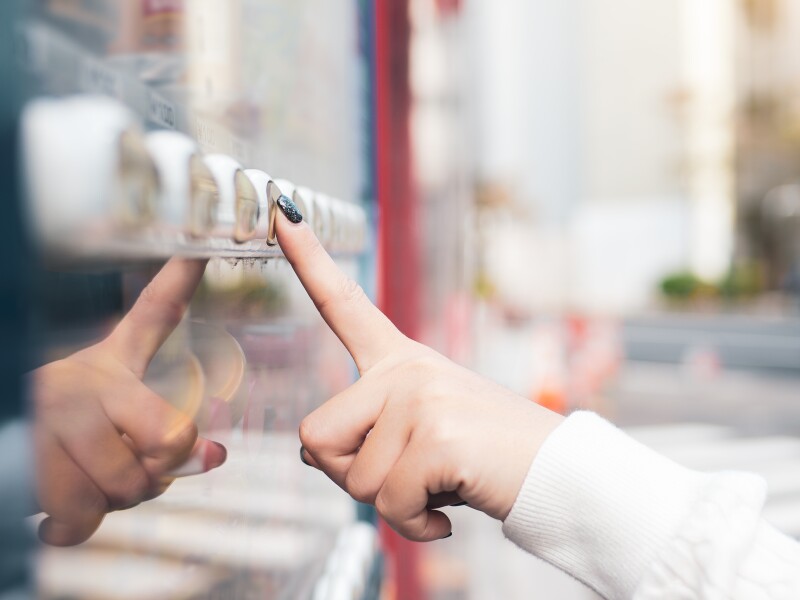 Crop image of woman buying a refreshing drink at a vending machine in Japan