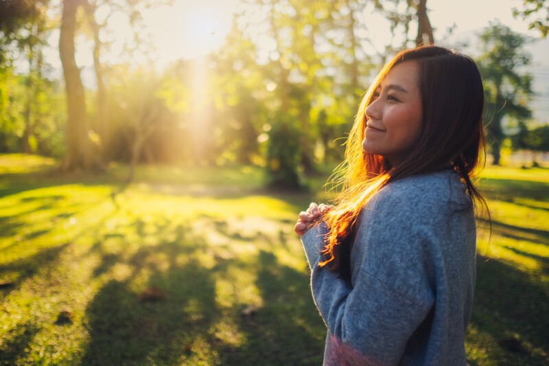Portrait image of a beautiful asian woman standing among nature