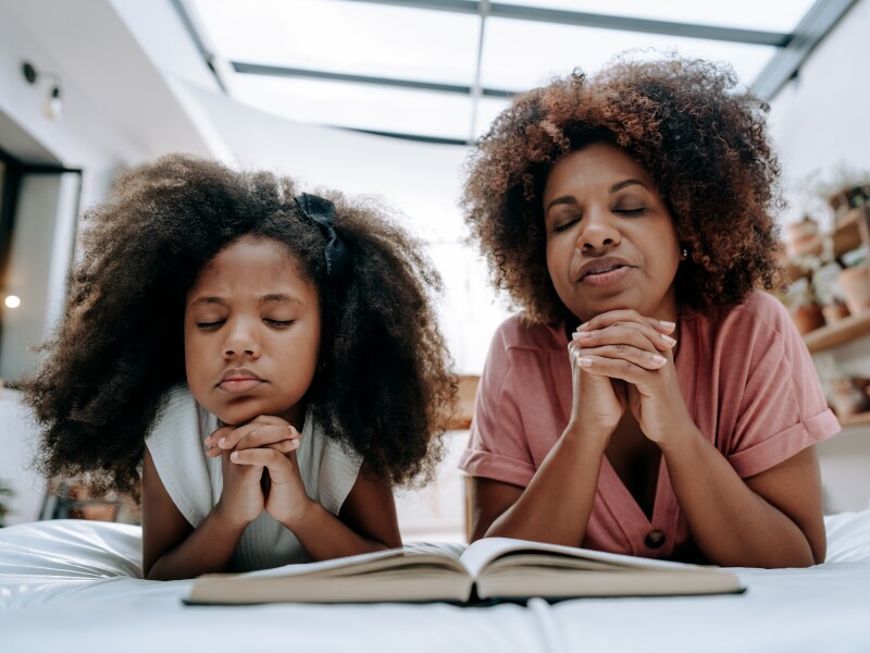 Mother teaches daughter to pray