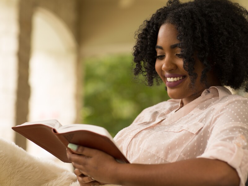 African American woman studing and reading the Bible.
