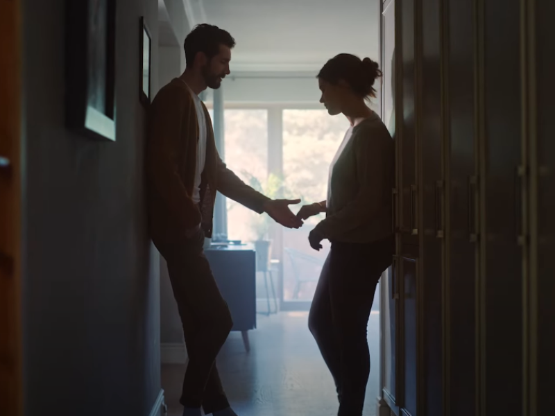 A husband reaches out his hand to his wife to comfort her.