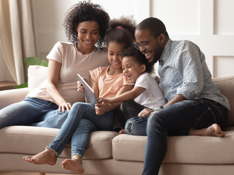 A family studies together on the couch.