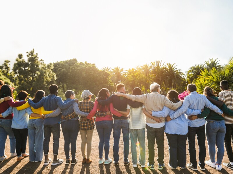 Group of multigenerational people hugging each others - Support, multiracial and diversity concept - Main focus on senior man with white hairs