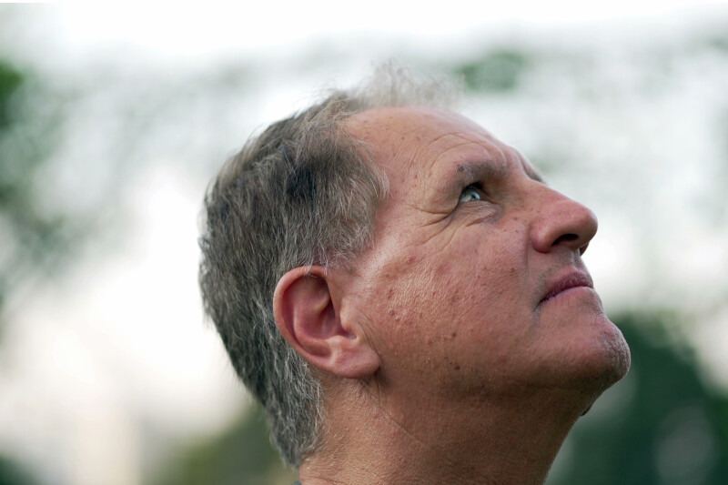 Meditative senior man looking up at sky with serious expression