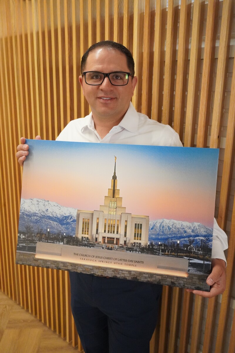 Eduardo Maradiaga holding a canvas print of his photograph.