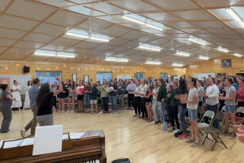 The young women of the Firth Idaho Stake singing and clapping along to their new song “I Am Enough” during girls camp
