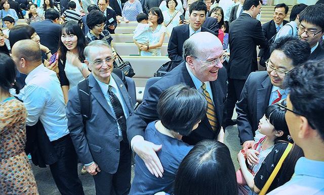 Image titleElder Cook greeting members in Asia. Image from Facebook.