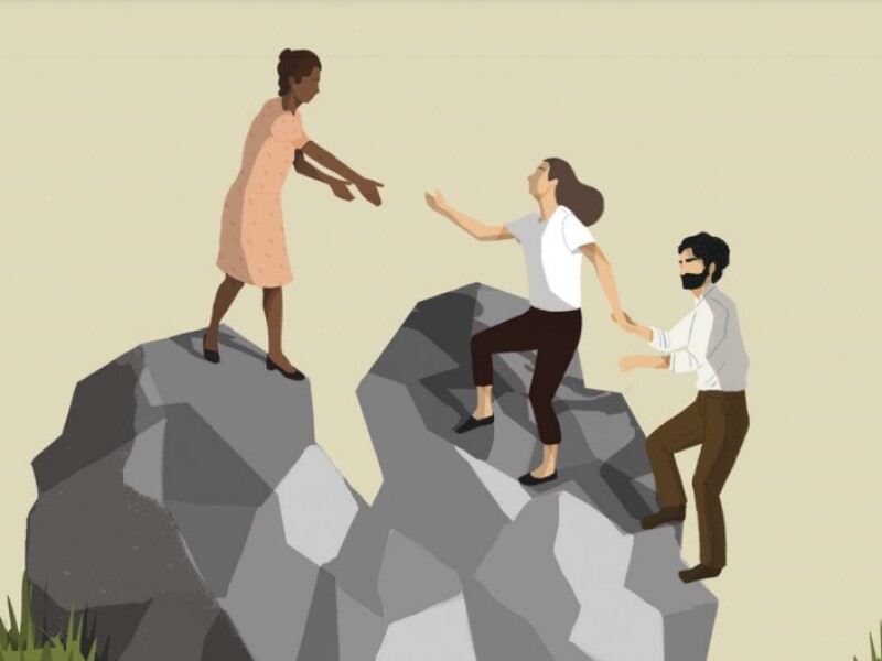 A woman helping a couple up steep rocks.