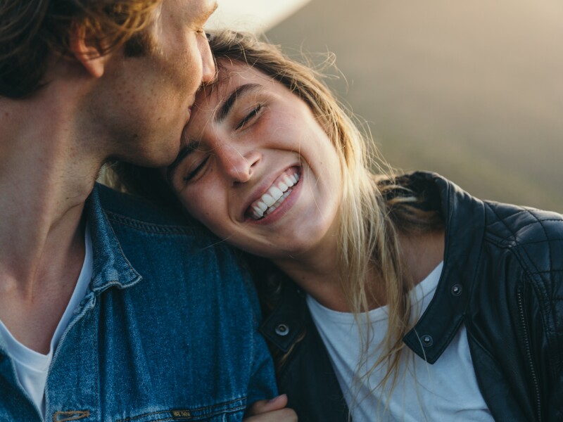 Romantic boyfriend kissing on happy girlfriend's forehead