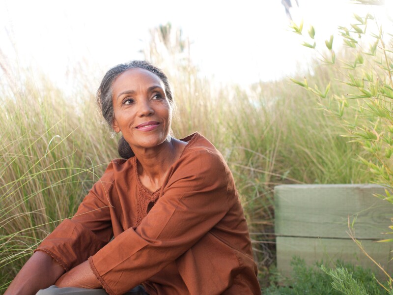 Serene woman sitting in sunny field