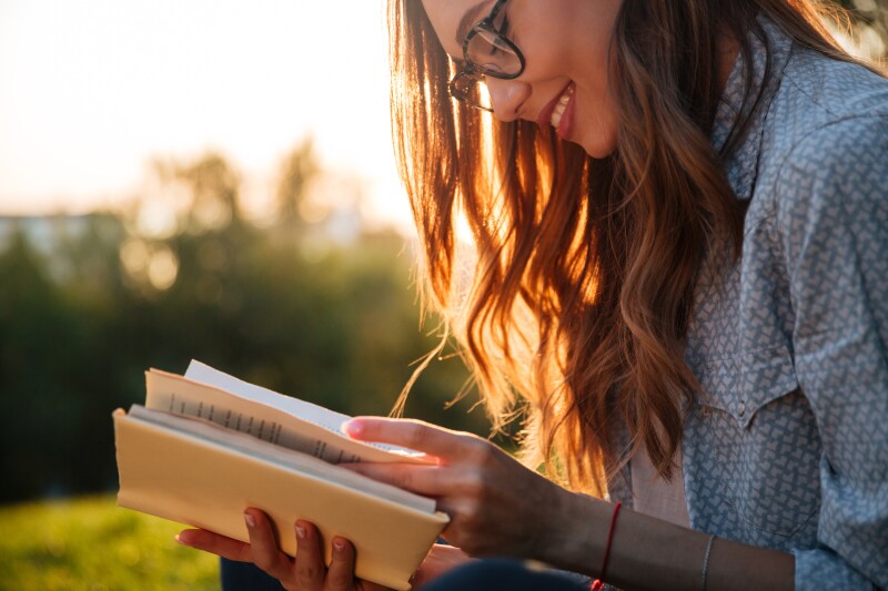 Cropped,Image,Of,Smiling,Brunette,Woman,In,Eyeglasses,Reading,Book