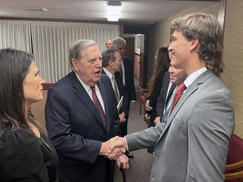 President Jeffrey R. Holland shakes a young man's hand.