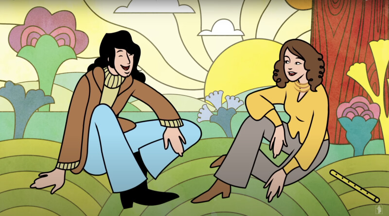 A young man and a young woman sitting on a hill talk and laugh together.