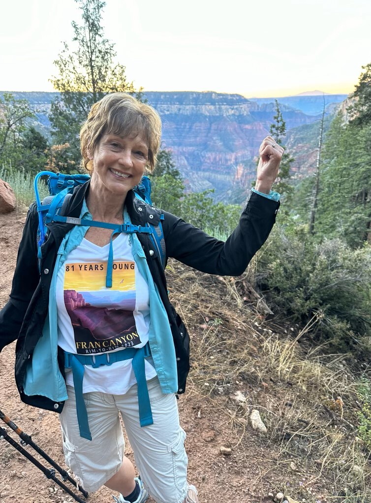 Fran pointing at the Grand Canyon behind her.