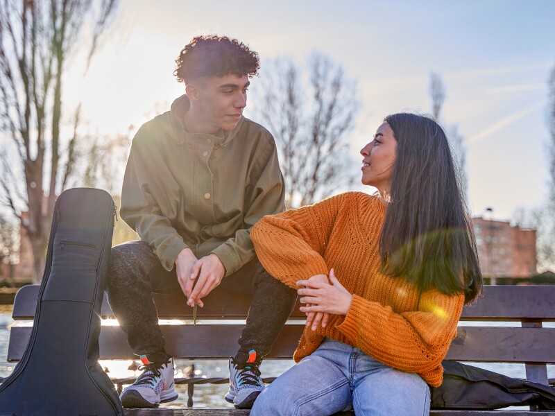Two,Happy,Friends,Are,Talking,And,Laughing,While,Sitting,On
