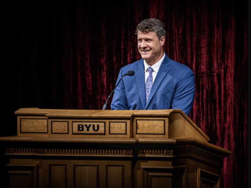 Steven C. Harper stands behind a podium at Brigham Young University.