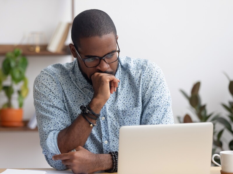 Confused man looks at his laptop.