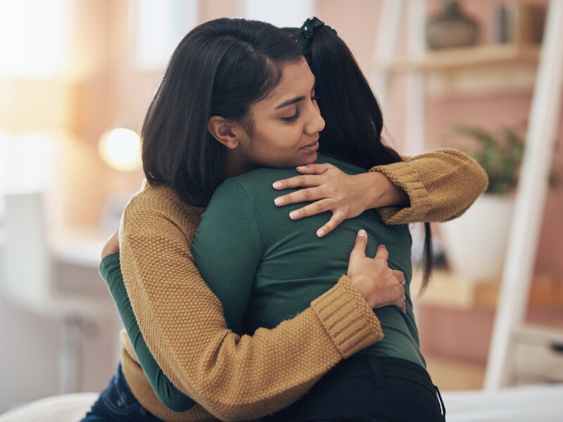 Cropped shot of two young women embracing each other at home