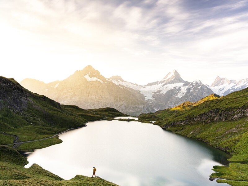 Hiker in the mist at dawn at Bachalpsee lake, Switzerland
