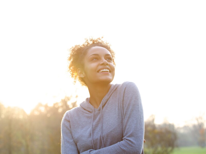 Happy young woman thinking and looking up