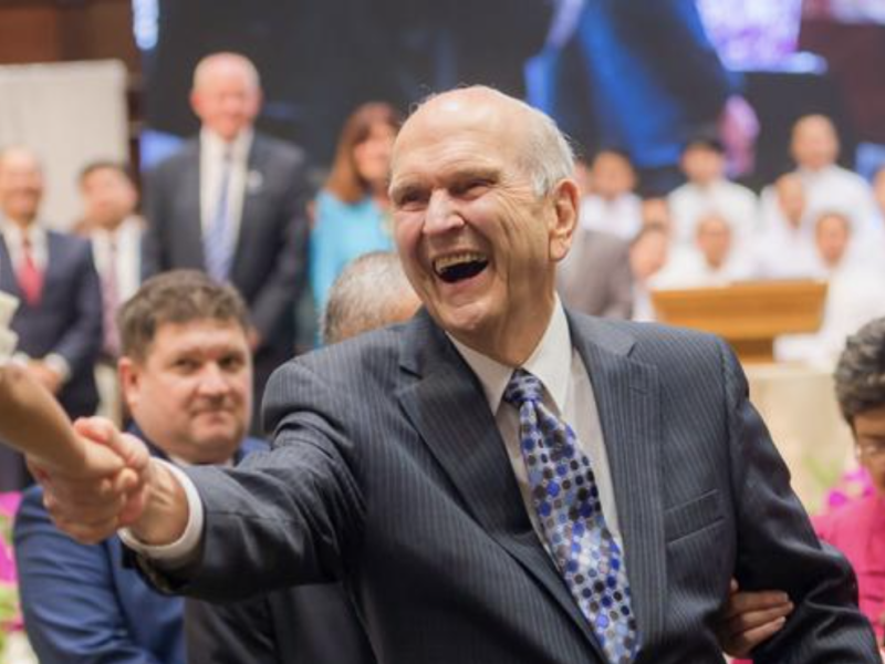 Russell M. Nelson smiles as he shakes a child's hand